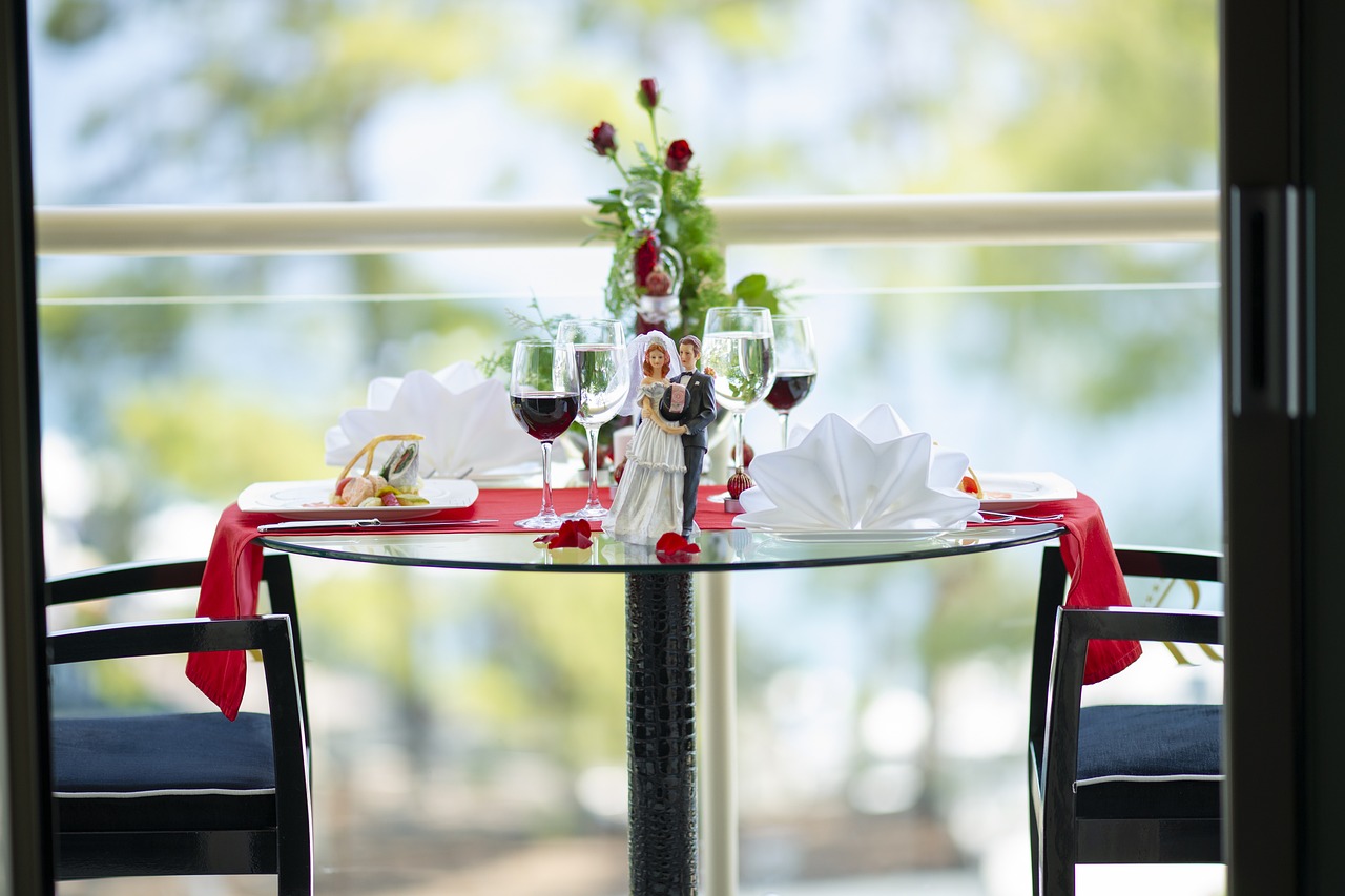 숙소 안 테라스 테이블이 로맨틱한 분위기로 꾸며져 있다.
테이블위에 장미 꽃이 뿌려져 있고 그 장미꽃 사이에 웨딩피규어가 가운데 있으며, 와인잔에 와인이 담겨있다.