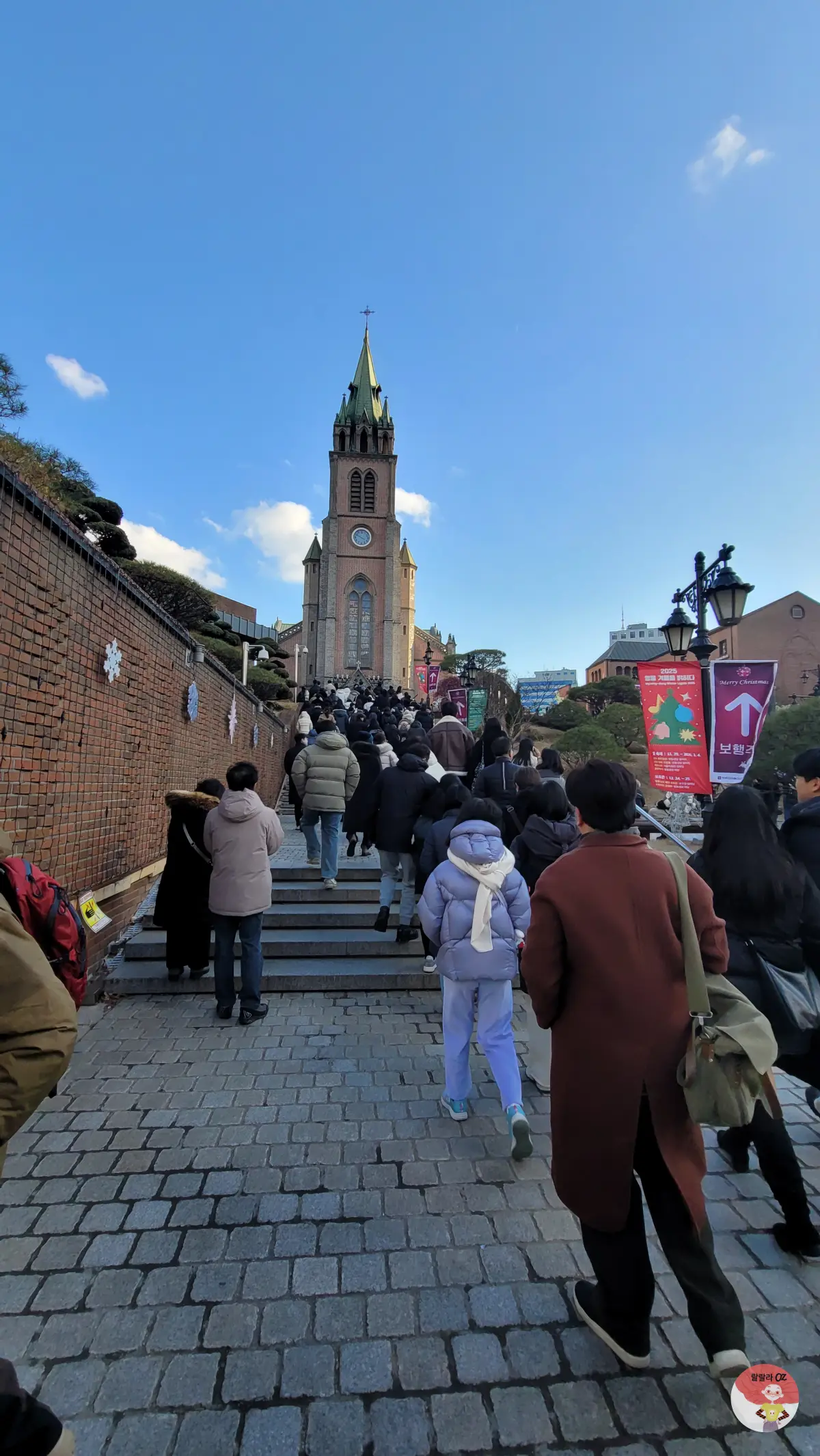 명동성당 가는 길, 계단을 오르는 사람들 너머로 명동 대성당 본당건물이 보인다.