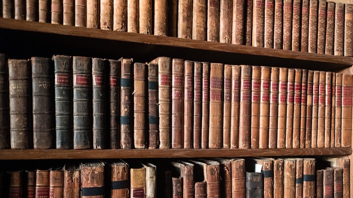 오래된 책들이 책꽂이에 많이 꽂혀있는 사진