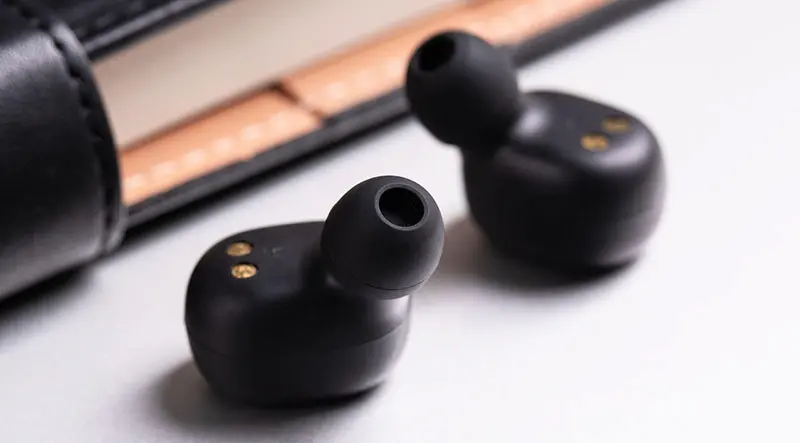 책상 위에 이어폰 1쌍이 놓여 있는 이미지.