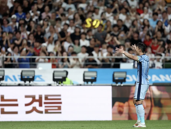 가득 찬 관중석을 향해 두 팔을 벌려 인사하는 손흥민