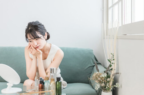 거친 피부를 신경쓰는 여성.