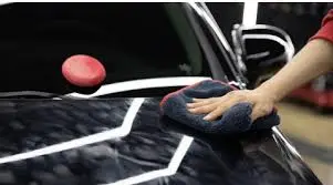 고체 왁스를 자동차 후드에 도포 하고 극세사 타월로 버핑을 하는 모습