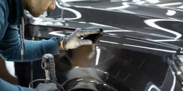 초음파 도장 두께 측정기로 중고차의 도장 상태를 확인하는 모습