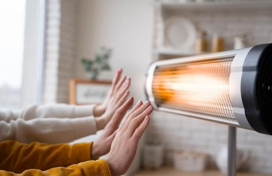 전기 난로에 손을 쬐고 있는 사진입니다.