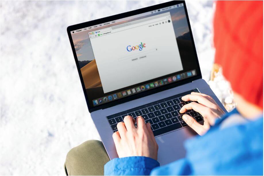 야외에서 노트북으로 구글을 검색하고 있는 사람