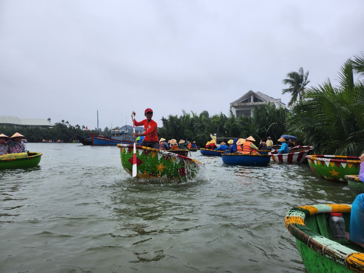 호이안의 전통 바구니배를 타고 투본강을 여행 중인 모습, 베트남의 정취와 자연이 어우러진 장면