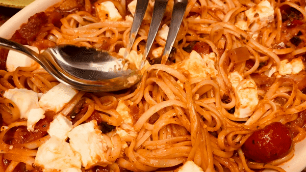 토마토 파스타-위-치즈를-포크와-수저로-섞는-모습