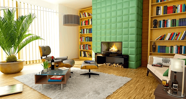 아파트 거실풍경이다. 노색으로 된 벽난로에 불이 타오르고, 아주 커다란 녹색식물이 있는 둥그런 화분이 있다. 책장에는 다양한 책들이 있다.