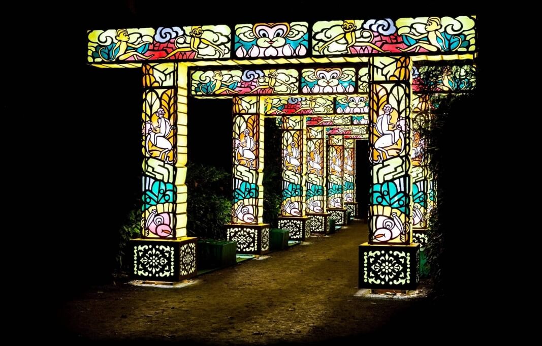 전통 문양과 그림이 새겨진 다채로운 색상의 아치형 등불들이 길게 이어져 환상적인 분위기를 연출하는 모습