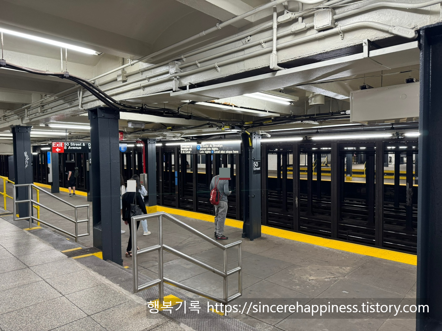 뉴욕 지하철 역사 내 C라인 타기 전에 승강장에서 사람들이 지하철 기다리고 있는 모습