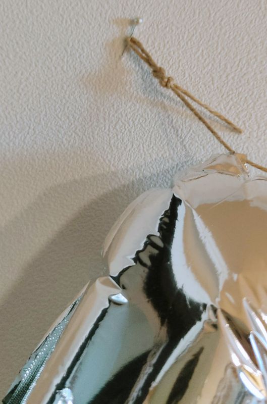 노끈 끝을 묶어주고 시침핀을 벽지에 꽂아 벽에 건 사진