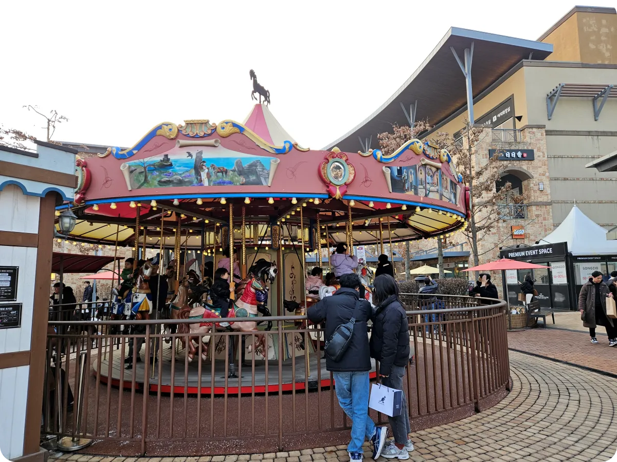 여주-프리미엄-아울렛-회전목마-타고있는-아이들-앞에서-사진찍는-부모님