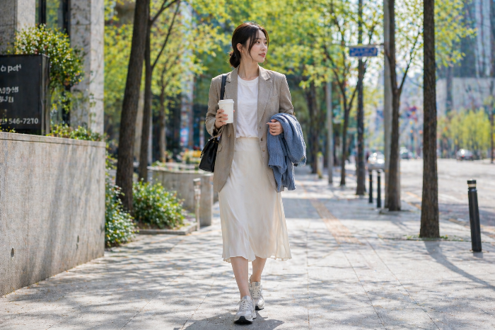 테일러드 재킷과 티셔츠, 미디 스커트와 스니커즈로 구성된 간절기 봄 출근룩