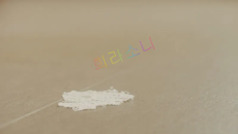 타일 바닥에 찢어진 드레스 조각이 놓여 있다.