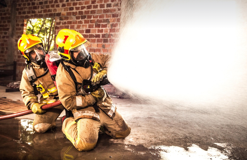 불길을 향해 물을 분사하며 진화 중인 두 명의 소방관. 영화 <소방관> 장면을 떠올리게 한다.
