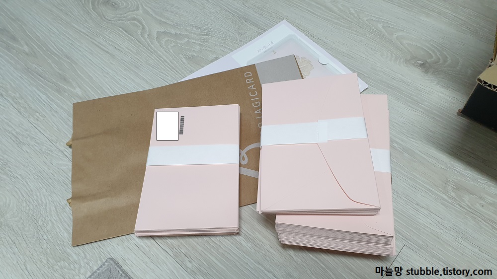 연한 분홍색 봉투가 쌓여 있다.