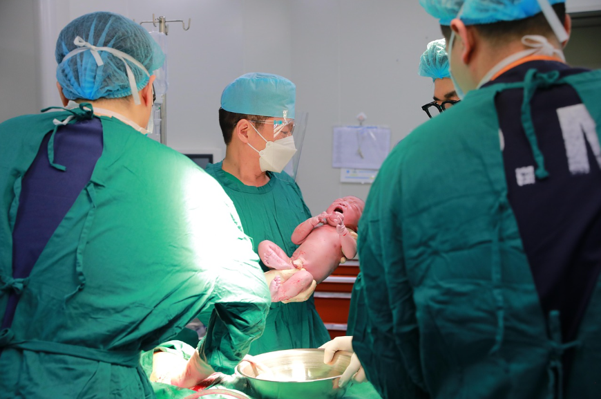 병원에서 갓 태어난 아기와 의료진