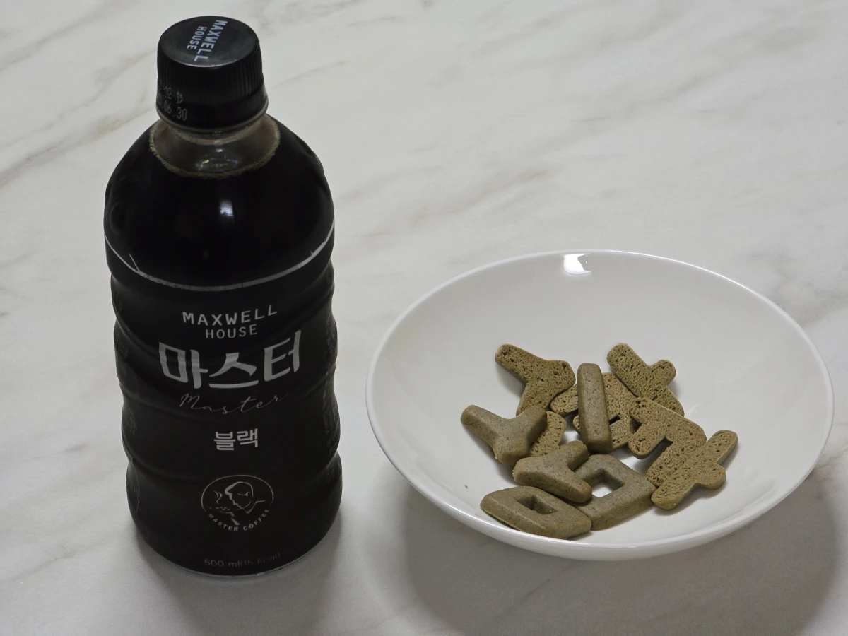 커피와 나란히 놓고 찍은 한글과자가 담겨있는 접시