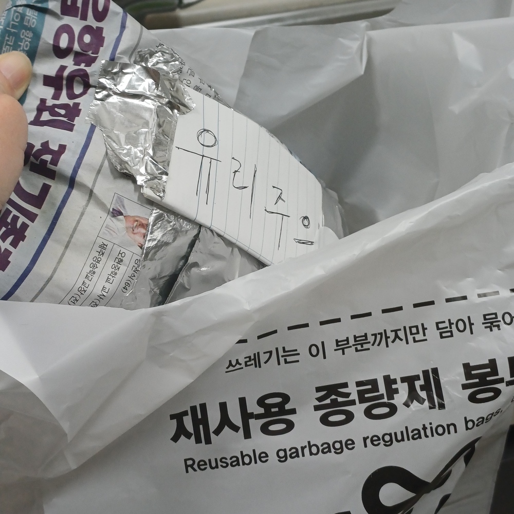 신문지로 감싼 깨진 유리를 &lsquo;유리 주의&rsquo; 표시 후 종량제 봉투에 넣어 정리한 모습
