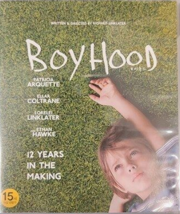 보이후드 영화의 포스터 어린 소년이 한쪽 팔을 뻗은채로 잔디밭에 누워있다 시선은 위로 응시하고 있다.