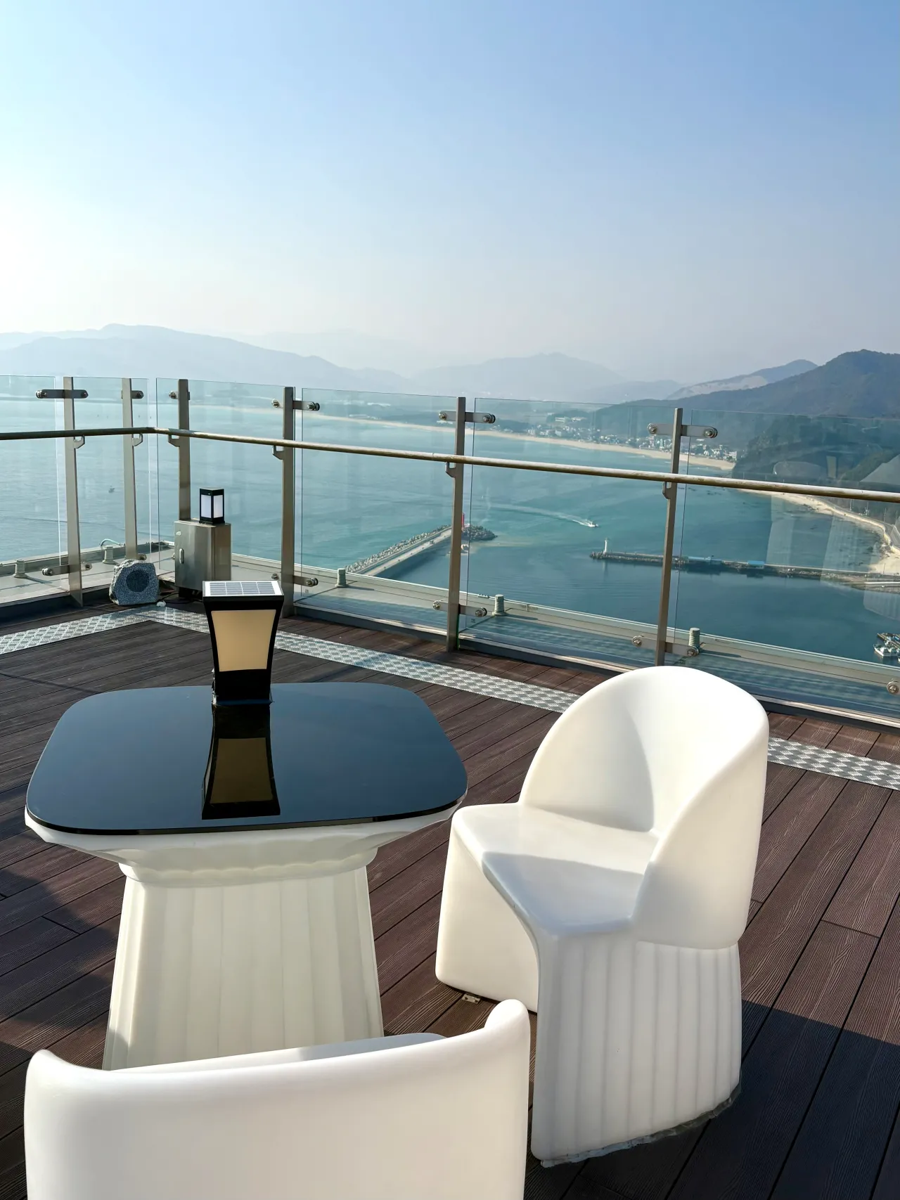 하얀의자와-테이블-앞에-유리-난간-바다뷰