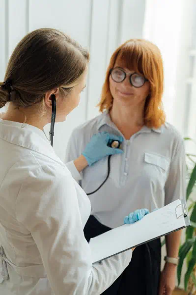 한 여성이 여의사에게 청진기로 검진을 받고 있다