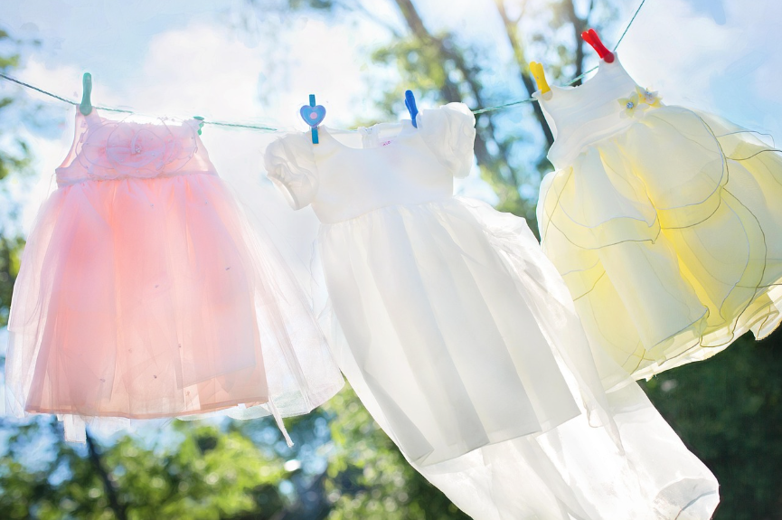 햇살 아래 줄에 걸려 말려지고 있는 깨끗하고 하얀 아기 드레스들과 빨래 꿈 해몽 이미지