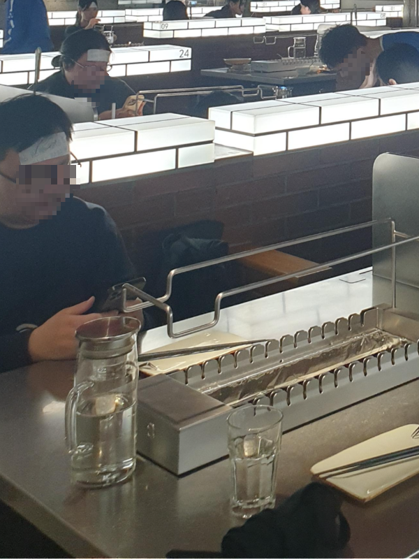 이마에 쿨 파스를 붙인 사람들이 앞뒤로 보인다.