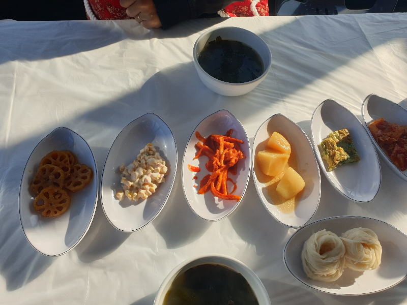 테이블 위에 다양한 찬들이 올려져 있다. 미역국도 보인다.