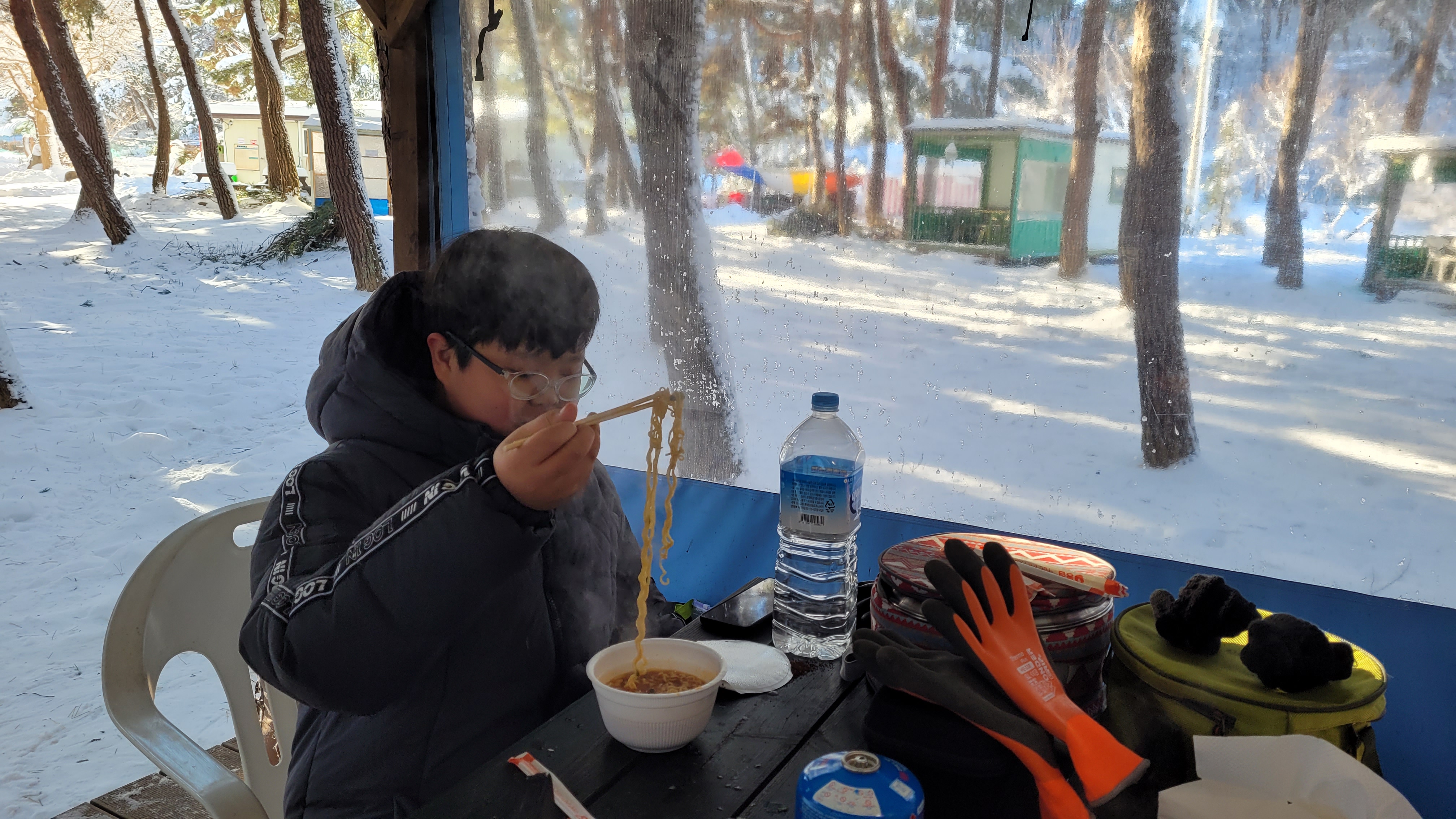 눈내린 방갈로에서 컵라면을 먹는 아들