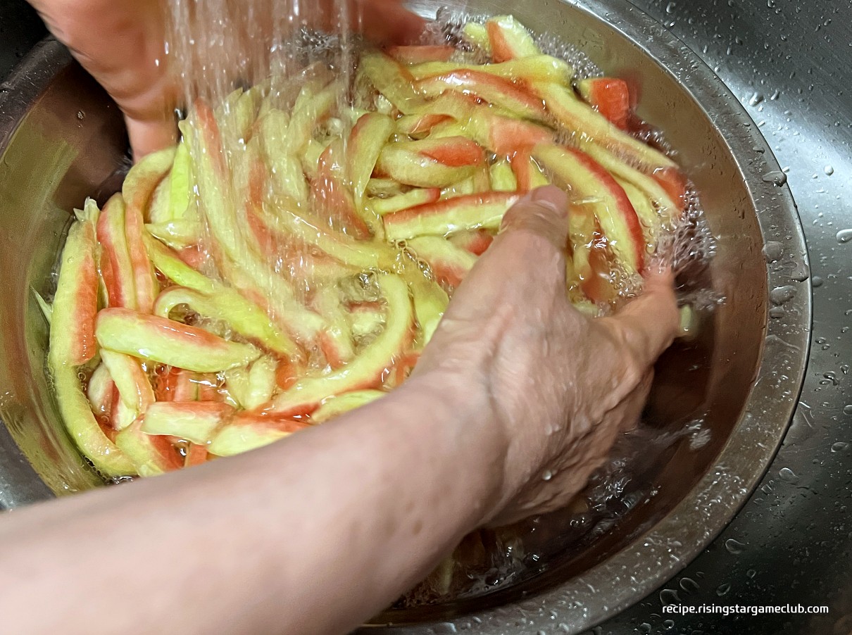 수박껍질(흰살) 무침에 들어갈 절여진 수박 흰살을 흐르는 물에 씻는 사진