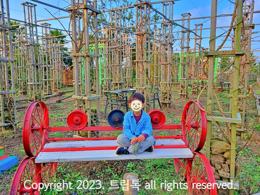 빨간 의자에 아빠다리를 하고 앉은 아이