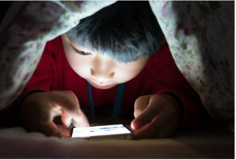 아이가 휴대폰을 보는 사진