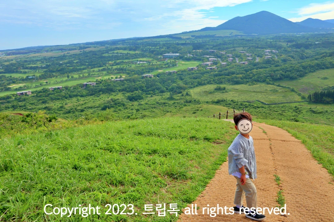아이의 뒤오 야자매트가 깔린 길과 짙은 녹색과 연두생 등으로 뒤섞인 멋진 자연풍경이 있다