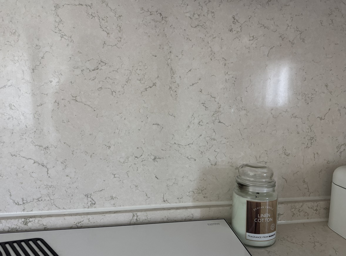 현대적인 인테리어에 사용된 고급스러운 엔지니어드 스톤 벽면과 상판의 상세 사진. 천연석의 단점인 틈새(줄눈)를 획기적으로 줄여 기밀성을 높인 신소재의 질감을 보여줌.