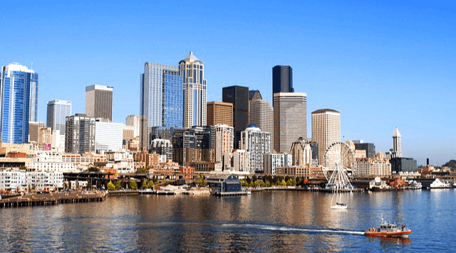 미국 시애틀의 건물 풍경이다. 수많은 고틍 빌딩들이 가득 세워졌고 앞에는 푸른 바다가 있다. 바다에는 보트가 달린다.