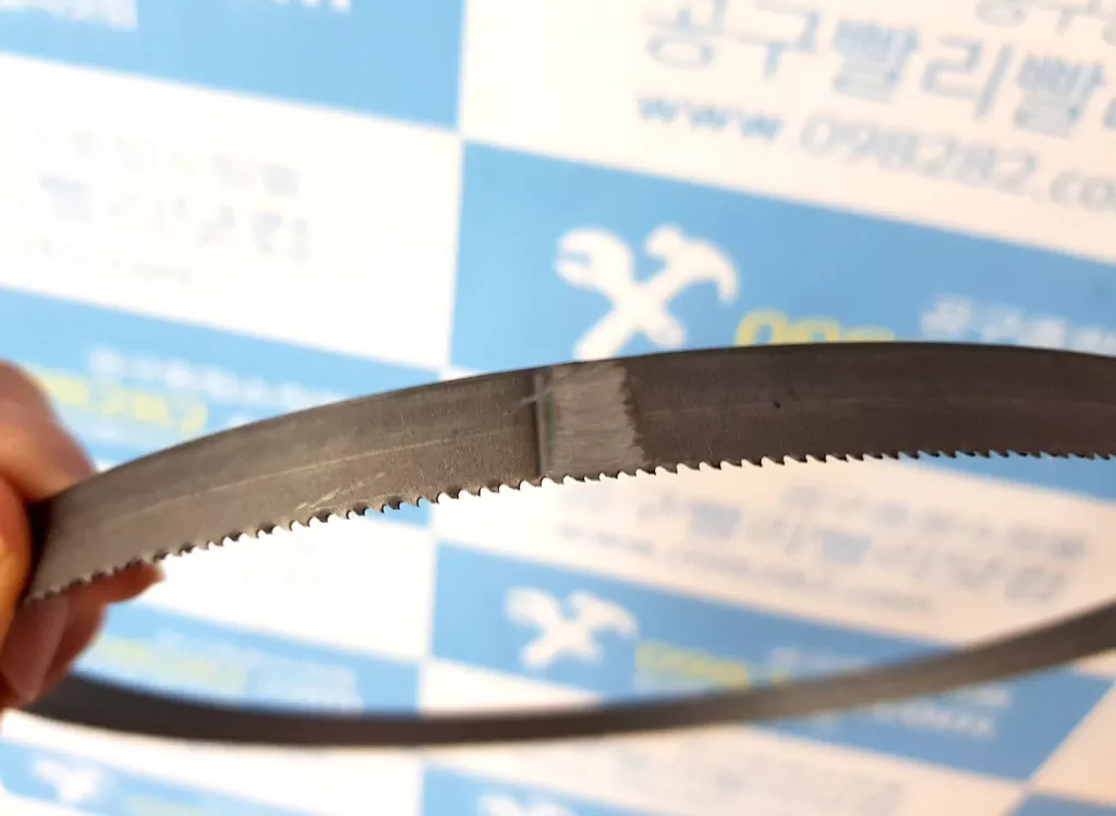 절단 시 각도 불량과 톱니 파손의 주원인이 되는 저가형 밴드쏘날의 거칠고 선명한 용접 접합부(열처리 불량) 단면 모습