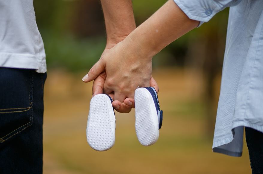 아기신발을 들고 있는 신혼부부의 손