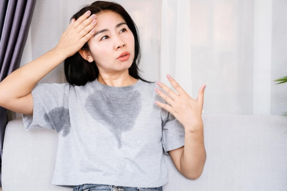 여자가 땀을 흘리며 더워하는 모습
