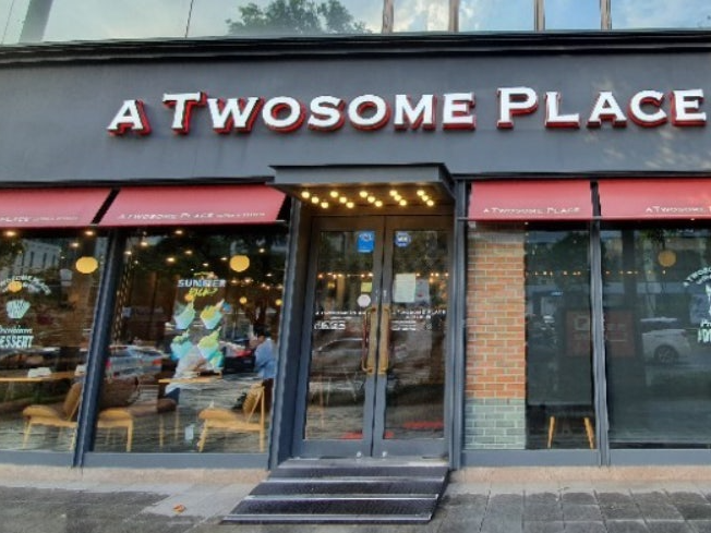 그레이 프레임과 간판 그리고 붉은 어닝으로 인테리어된 투썸 플레이스