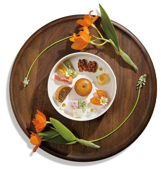 경복궁 생과방 주악세트. 나무로 된 둥근 쟁반 위에 꽃 두 송이가 하나의 접시를 감싸고 있으며, 접시 안에는 주악세트가 준비되어 있다.