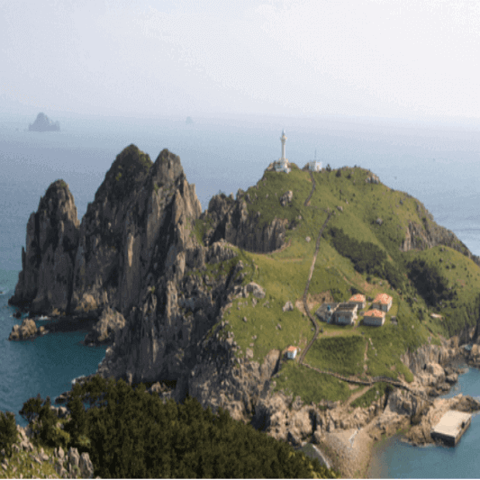 바다와 섬 그리고 등대와 조금한 집들이 있다.