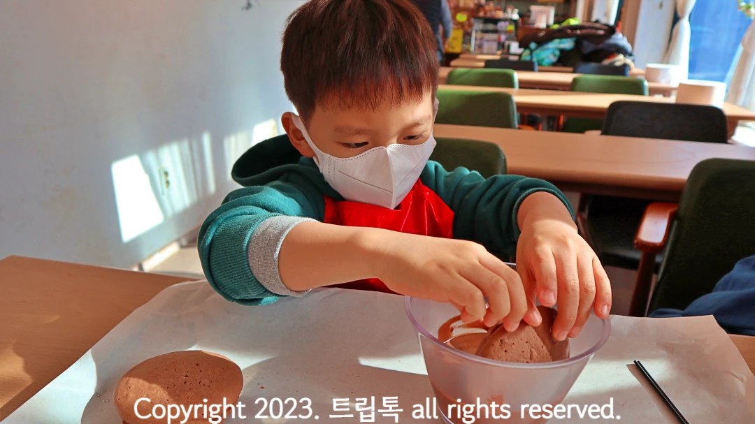 그릇에 담근 초코를 빵에 바르고 있다