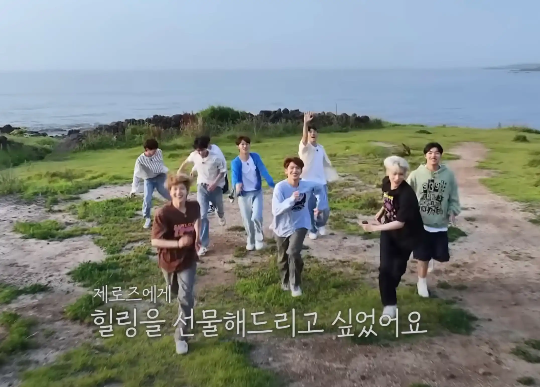 들판에서 뛰고 있는 제로베이스원 8명