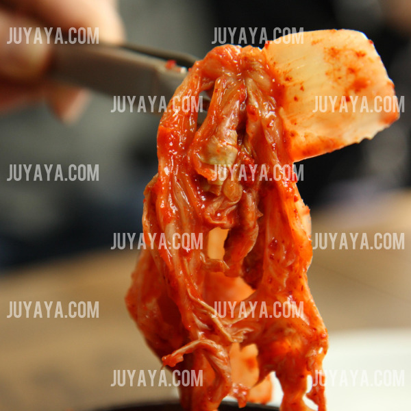 김장을 마친 김치 한 조각의 디테일 샷 - 숟가락 위에 올려진 김치 한 조각으로&amp;#44; 배추와 양념의 결이 선명하게 나타남.