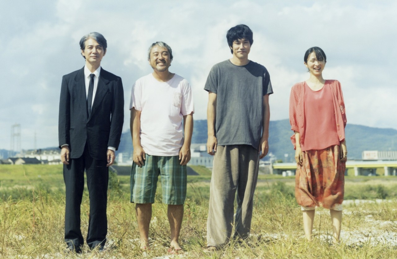 강변의 무코리타 주인공들이 강가에 나란히 서서 정면을 향해 환하게 웃는 모습