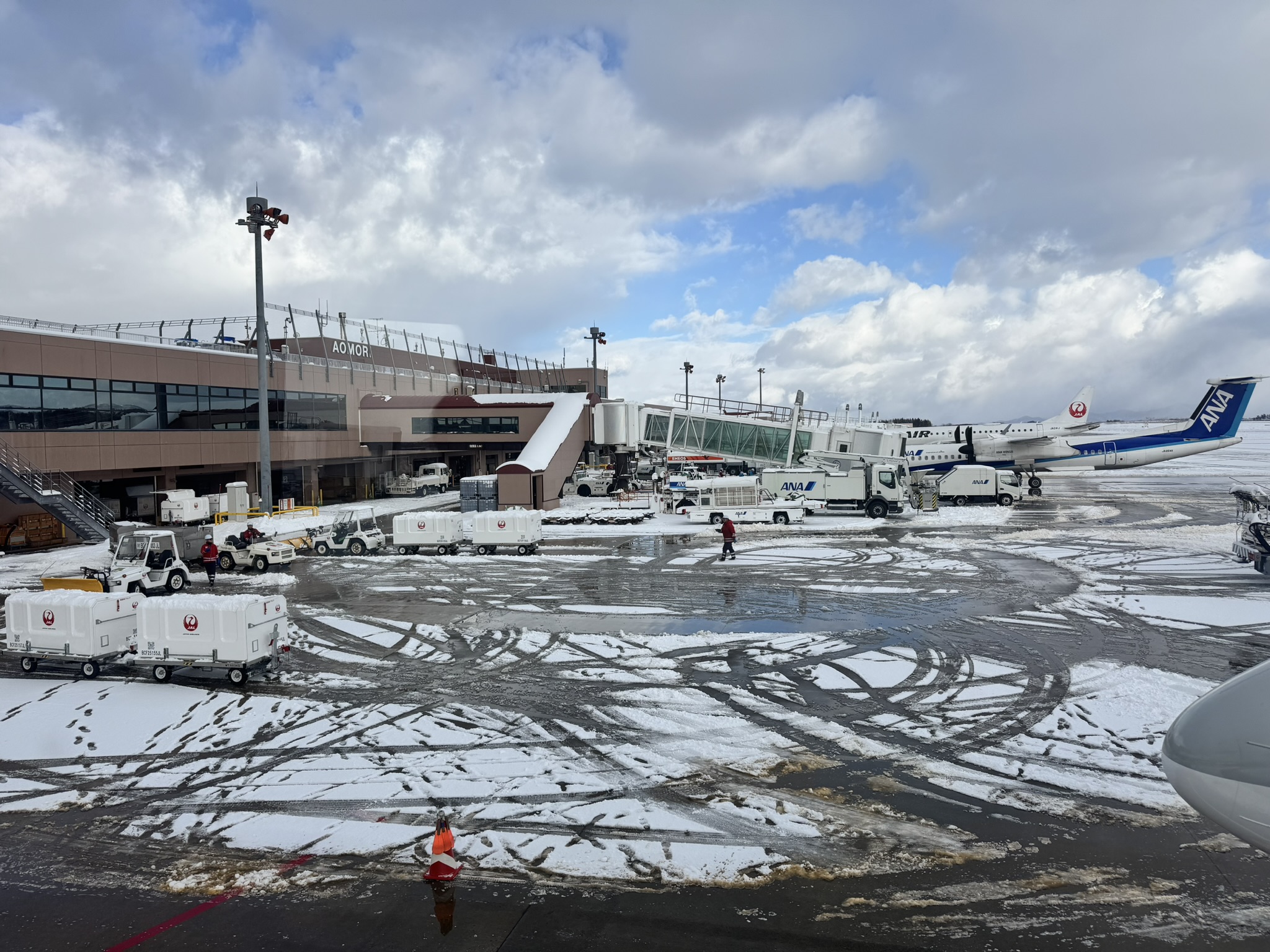 눈 내린 아오모리 공항 활주로 전경과 ANA 항공기, 지상 조업 차량들의 모습