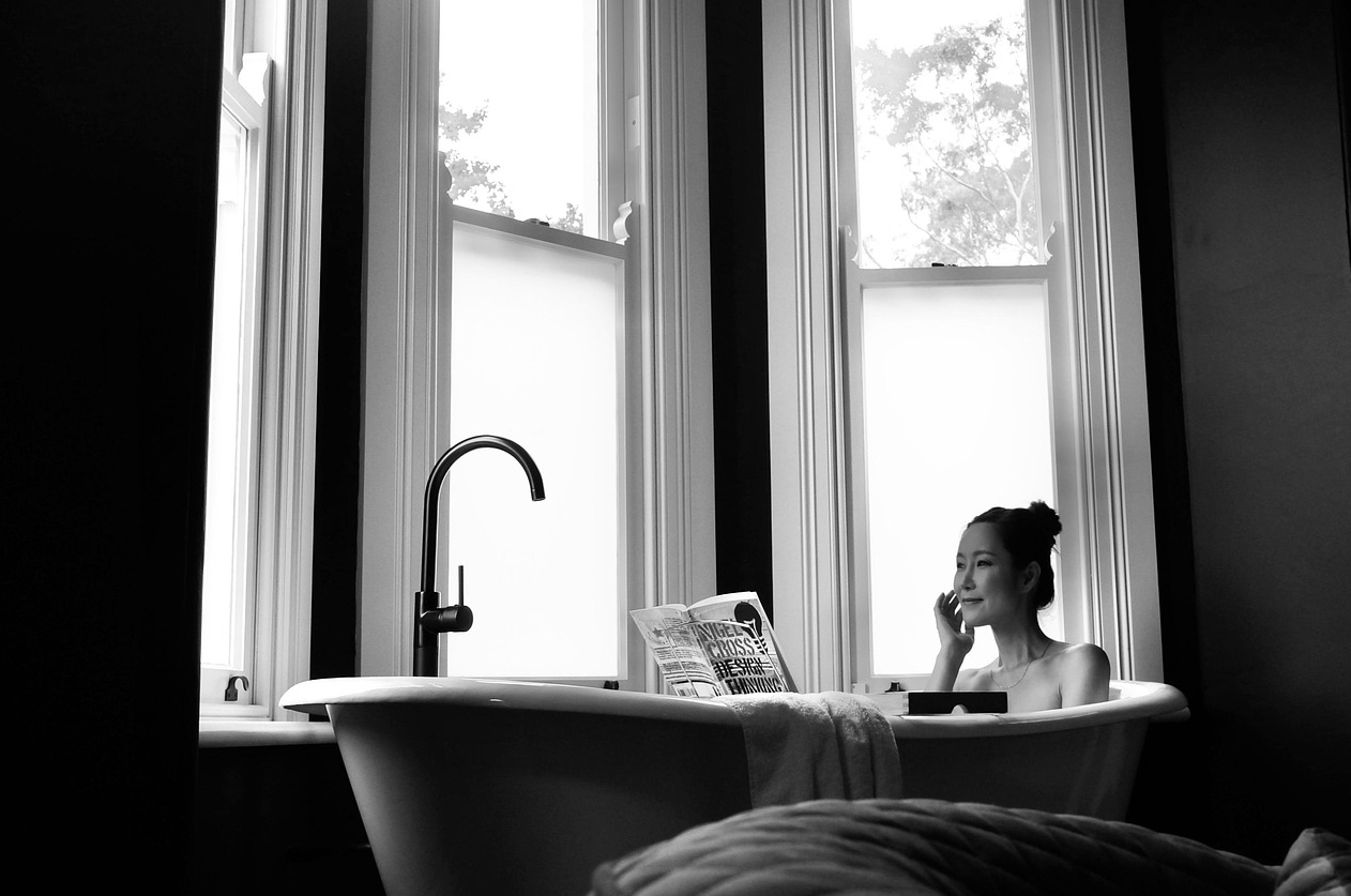 한 여성이 욕조안에서 책을 보며 반신욕을 즐기고 있다