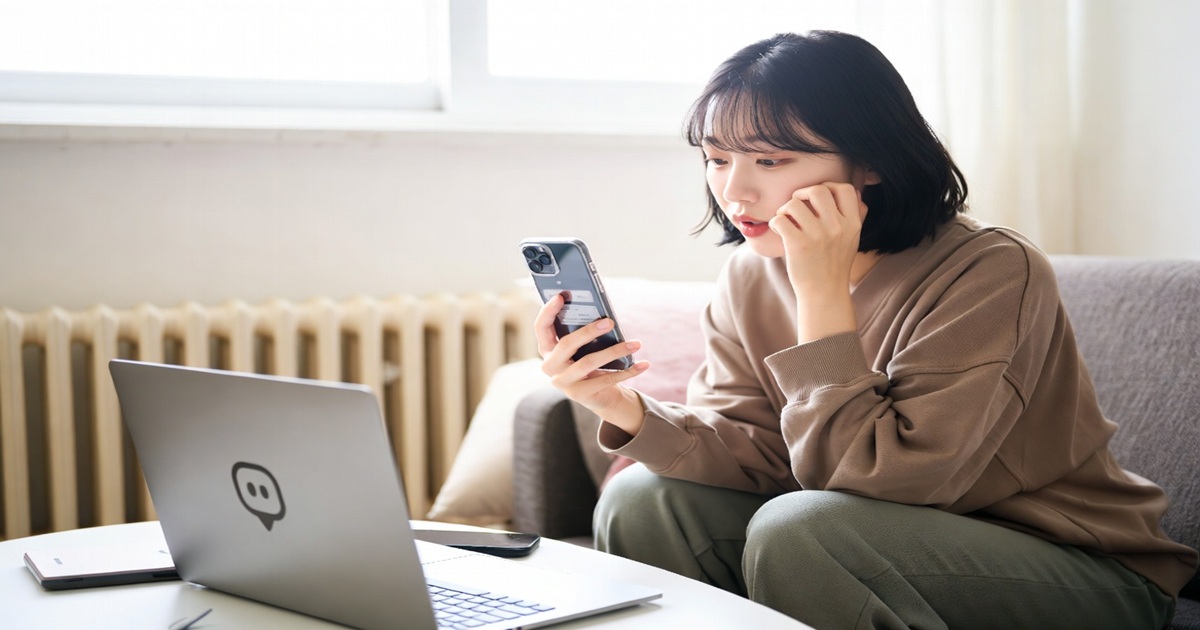 집에서 노트북과 핸드폰을 사용해서 온라인 부업을 하고 있는 장면